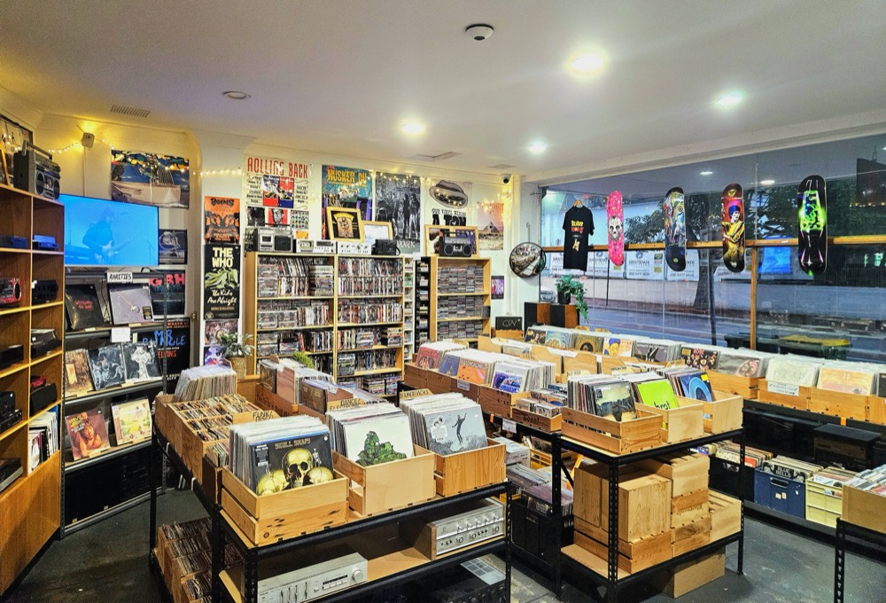 Inside the shop: wooden crates full of vinyl, with CDs and DVDs on the shelves behind